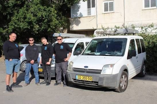 צוות אומגה מיזוג אוויר ליד רכב השירות של החברה